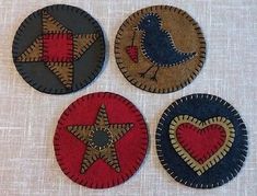 four handmade coasters with birds and stars on the top one has a heart