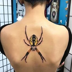 a spider tattoo on the back of a woman