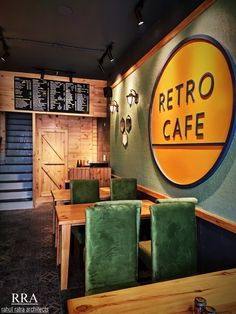 the interior of a restaurant with wooden tables and green chairs in front of a sign that reads retro cafe