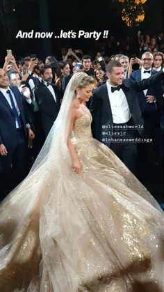 a woman in a wedding dress is walking down the aisle with her groom and guests