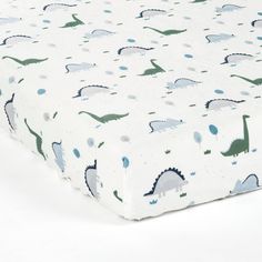 a baby crib sheet with dinosaurs on it