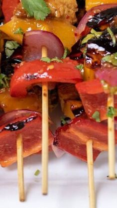 several skewers filled with different types of food on wooden toothpicks and garnished with cilantro