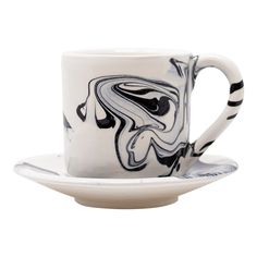 a black and white coffee cup on a saucer with an abstract swirl design in the middle