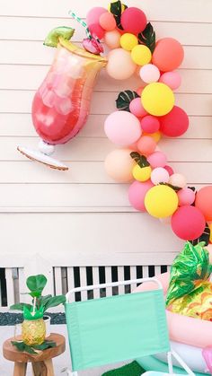 a tropical themed birthday party with balloons and pineapples on the front porch area