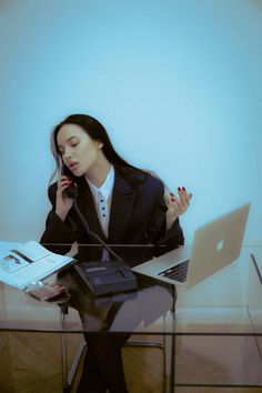 a woman sitting at a desk talking on the phone