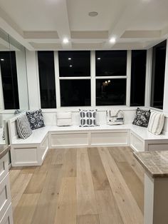 a room that has some white couches and windows on the wall in front of it