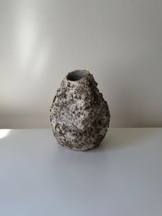 a stone vase sitting on top of a white table