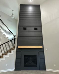 an empty room with a fireplace and stairs