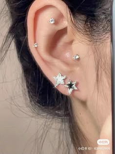 an ear with three small stars on it's side and one smaller star in the middle