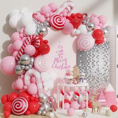 a pink and white christmas themed party with balloons, candy canes and other decorations