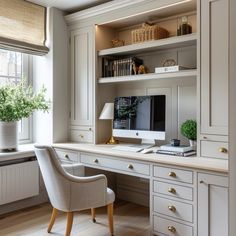 a home office with white cabinets and drawers