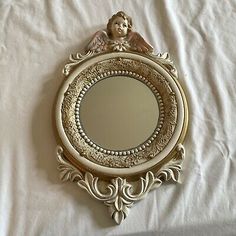 a mirror with an angel on it sitting on a bed