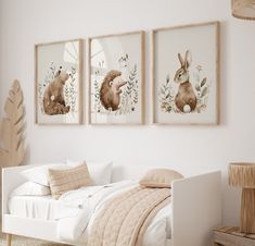 three framed pictures hang on the wall above a bed in a room with white walls