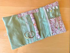 a green purse sitting on top of a wooden table next to a pair of scissors