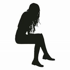 a silhouette of a woman sitting on the ground