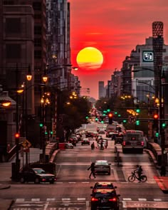 the sun is setting over a city street with cars and bicycles driving down it's lane