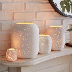 three white candles sitting on top of a table