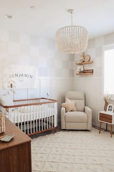 a baby's room with a crib, rocking chair and chandelier