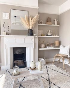 a living room filled with furniture and a fire place in front of a white fireplace