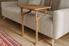 a couch with a wooden table on top of it next to a rug and chair