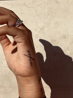 a woman's hand with a small tattoo on her left wrist and the word faith written in cursive writing