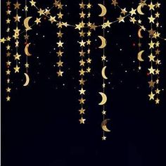 stars and crescents hanging from strings against a black background with the moon in the sky