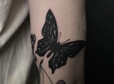 a black and white butterfly tattoo on the arm