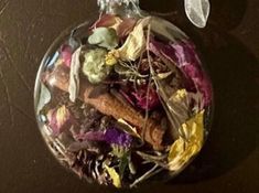 a glass ornament filled with dried flowers and herbs