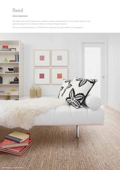 a white couch sitting on top of a wooden floor next to a bookshelf