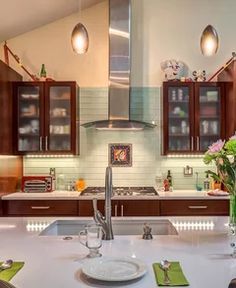 a kitchen with wooden cabinets and white counter tops, green napkins on the table