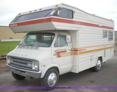 an rv parked in a parking lot next to a building