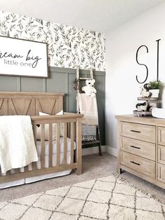 a baby's room with a crib, dresser and changing table in it