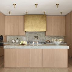 a large kitchen with wooden cabinets and marble counter tops, along with stainless steel appliances