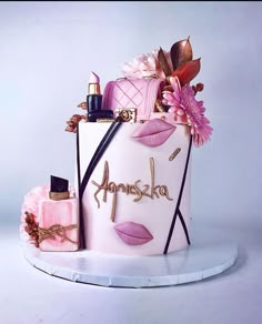 a cake decorated with lipstick, perfume bottles and flowers