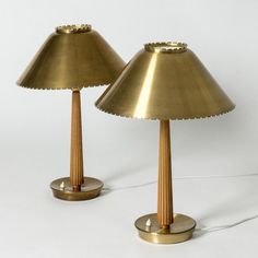 two brass lamps are sitting next to each other