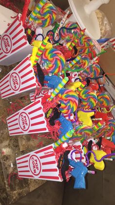 many candy lollipops are lined up on the floor next to buckets