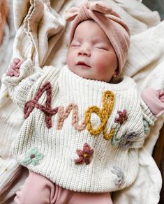 a newborn baby wearing a sweater and hat