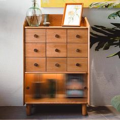 a wooden dresser sitting next to a potted plant