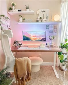 a desk with a computer on top of it and some plants in front of it