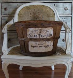 a wooden basket sitting on top of a white chair