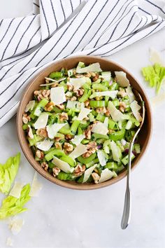 a bowl filled with celery and nuts on top of a white table cloth