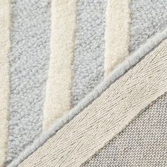 closeup of the corner of a rug with several different colors and sizes on it