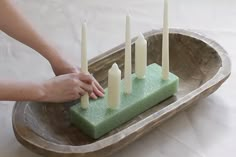 a person is placing candles on a tray