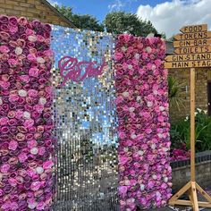 pink flowers are arranged on the side of a building