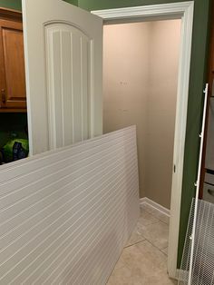 an empty kitchen with green walls and white trim