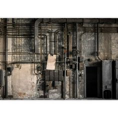 an old industrial building with pipes and paper hanging on the wall in front of it