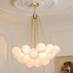 a chandelier hanging from the ceiling in a room with white walls and flooring