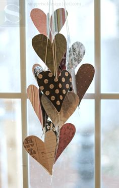 several hearts hanging from a string in front of a window