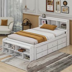 a white bed with drawers underneath it in a room