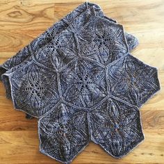 two crocheted placemats sitting on top of a wooden table next to each other